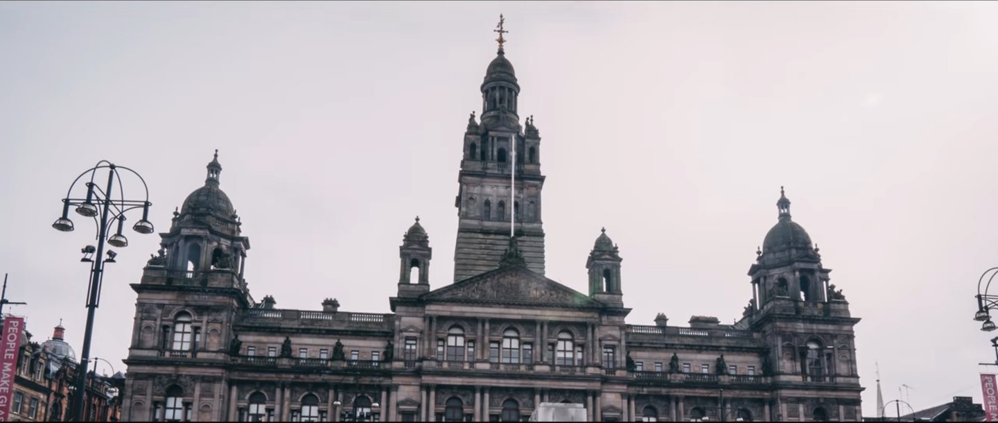 Ornate stone civic building with a clock tower under a grey sky